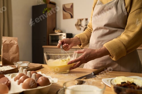 Preview: Middle Aged Woman Whisking Eggs in Glass Bowl While Baking at Home