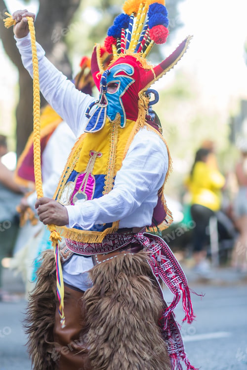 Preview: Hispanic man dancing with traditional clothes and mask during parade. Dia de la hispanidad