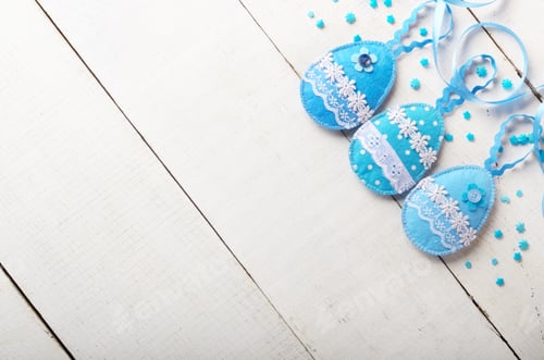 Preview: Handmade patchwork blue felt easter eggs on white wooden table