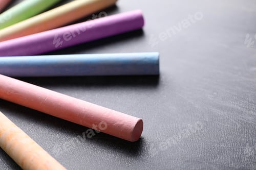 Preview: Pieces of color chalk on blackboard, closeup. Space for text