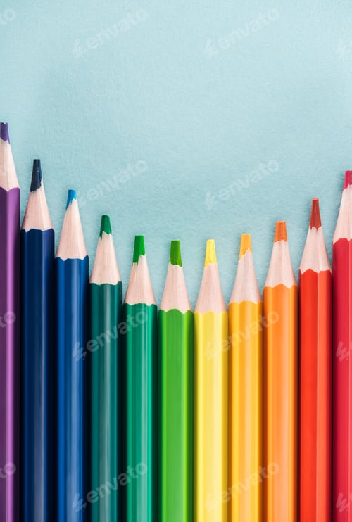 Preview: top view of rainbow multicolored pencils on blue background, lgbt concept