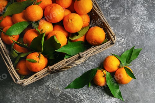 Preview: Fresh Tangerines in a Woven Basket on Gray