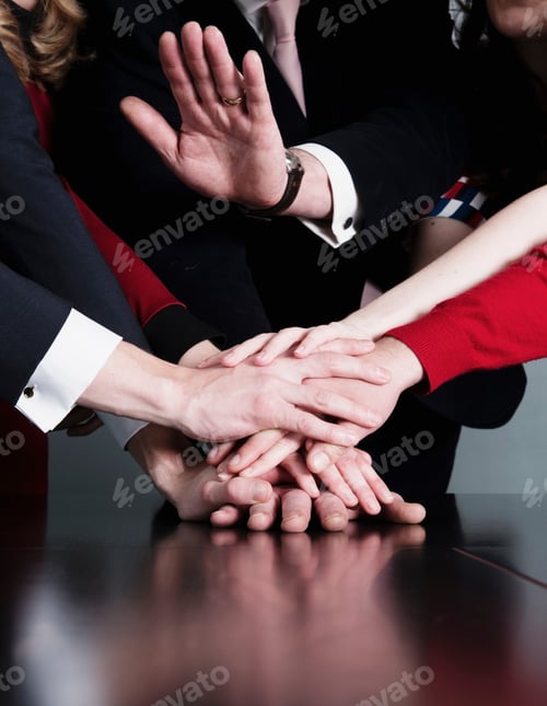Preview: Closeup of business team putting their hands on top of each other