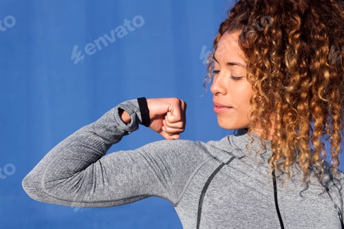 Preview: female athlete with curly hair showing bicep