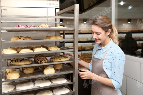 Preview: Baker at rack with pastries in workshop