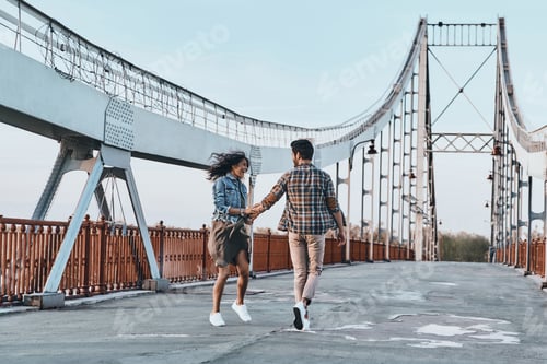 Preview: Making Each Other Happy. Full Length Of Playful Young Couple Holding Hands While Walking On The