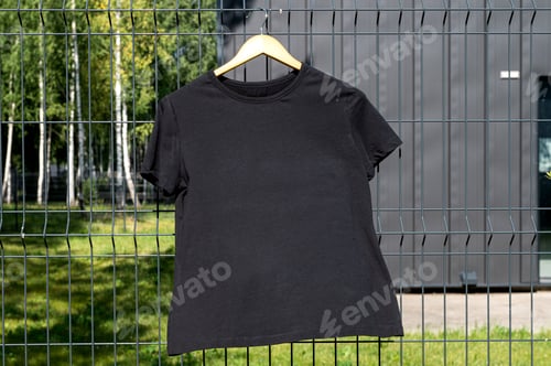 Preview: A mockup of a black T-shirt with short sleeves is hanging on a hanger