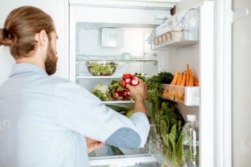 Preview: Man with fresh vegetables at the kitchen
