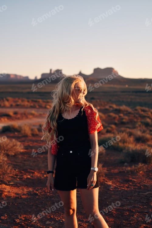 Preview: Woman with long blonde curly hair in the desert at sunset