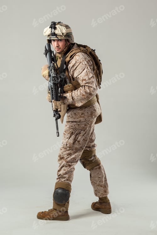 Preview: Soldier in military gear carrying rifle in studio setting during daylight hours