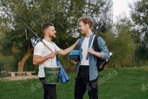 Preview: Two men standing and carrying fishing equipment outdoors