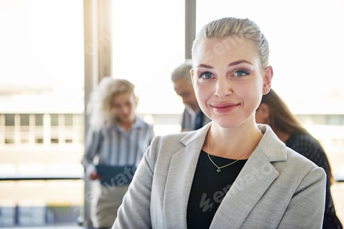 Preview: Professional Woman in Office with Colleagues Behind