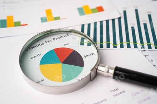Preview: Magnifying glass on charts graphs paper.