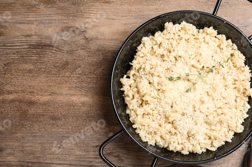 Preview: Delicious risotto with cheese on wooden table, top view. Space for text