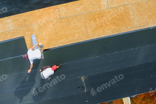 Preview: New asphalt bitumen shingles being installed on roof of a residential building