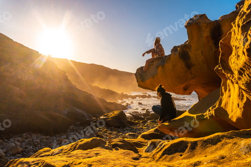 Preview: Lifestyle of two friends at sunset in the cove of stones in the Jaizkibel mountain