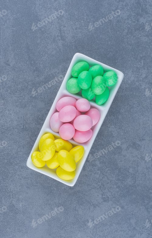Preview: Yellow , green,and pink gums on the plate, on the marble background
