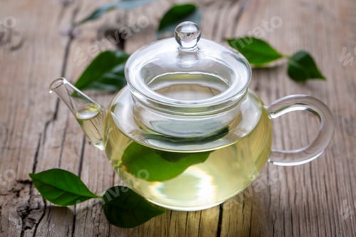 Preview: Cup of healthy green tea with tea leaves.