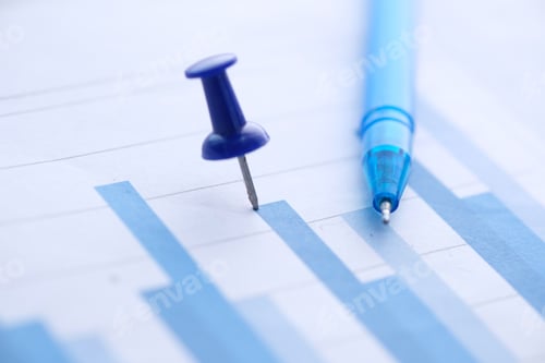 Preview: Close up of bar charts with push pin and pen on table