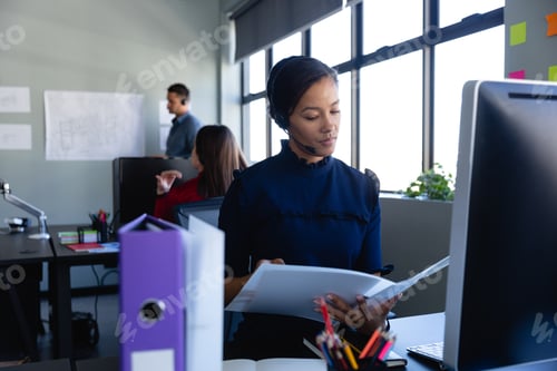 Preview: African American woman working with headset phone in office