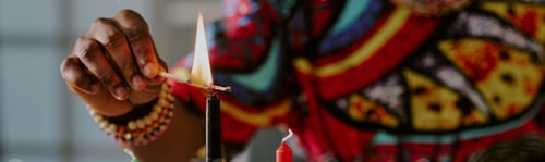 Preview: Black Woman Lighting Kwanzaa Candle during Cultural Holiday Celebration
