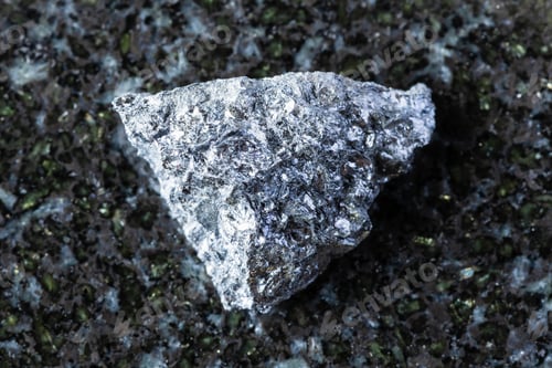 Preview: sample of raw hulsite mineral on black granite