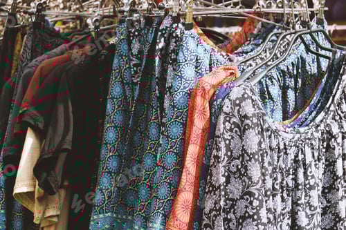 Preview: Clothing Rack Filled With Patterned Shirts and Dresses