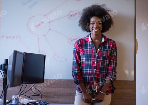 Preview: African American woman writing on a chalkboard in a modern offic