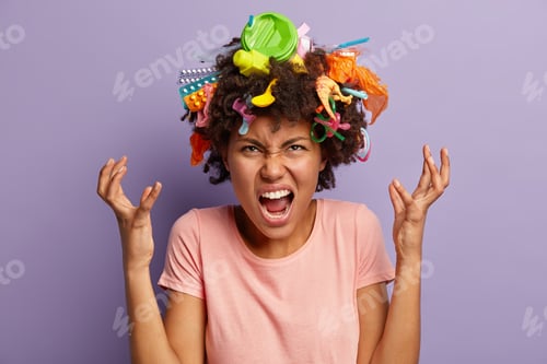 Preview: Irritated dark skinned woman screams angrily, raises hands, demonstrates garbage she collected on ha