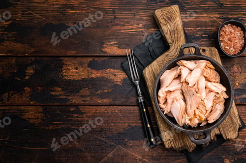 Vista previa: Filete de salmón asado cocido, carne de pescado desmenuzada en una sartén. Fondo de madera. Vista superior