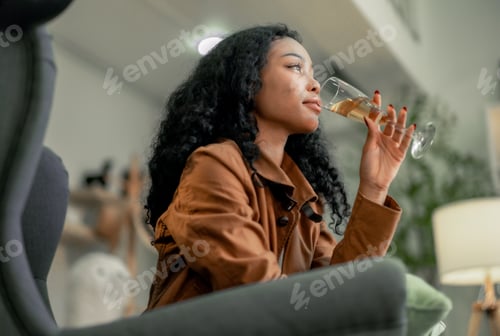 Preview: Young Black Female Designer Relaxes With a Glass of Wine Post-Work in Cozy Studio