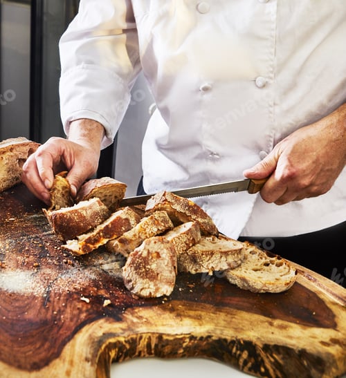 Preview: Homemade Italian focaccia bread is cut with a knife on a wooden board