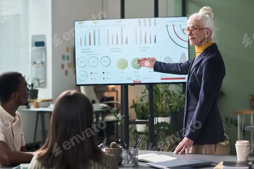 Preview: Senior Businesswoman Presenting Data Analysis to Team