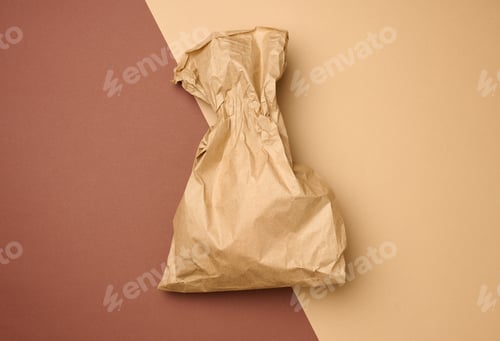 Preview: Full brown paper disposable food bag on a beige background, concept of delivery and ordering