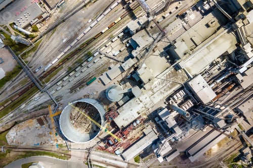 Preview: Aerial view of cement factory with high concrete structure and tower crane at industrial production