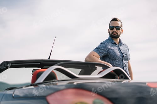 Preview: Attractive man posing in convertible car.
