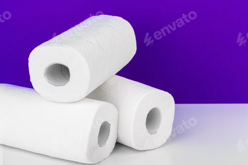 Preview: Roll of paper towel on table against purple background