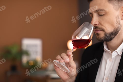 Preview: Young man with glass of wine indoors