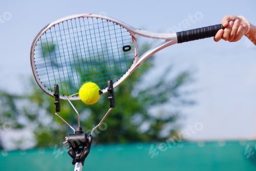 Preview: Tennis racket hitting ball on training tool, outdoor practice.