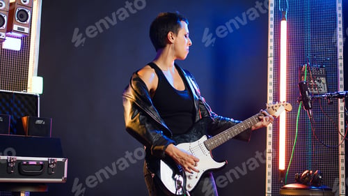 Preview: Woman performer showing thumbs up symbol and playing guitar