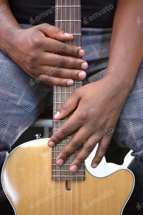 Preview: Black millennial unrecognizable man holds his guitar