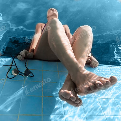 Preview: bottom view of female swimmer resting at swimming pool