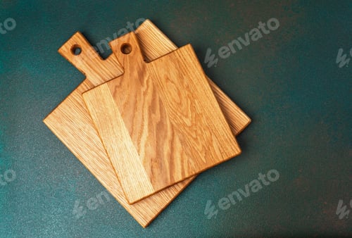 Preview: Wooden cutting boards stacked on a textured surface in natural light