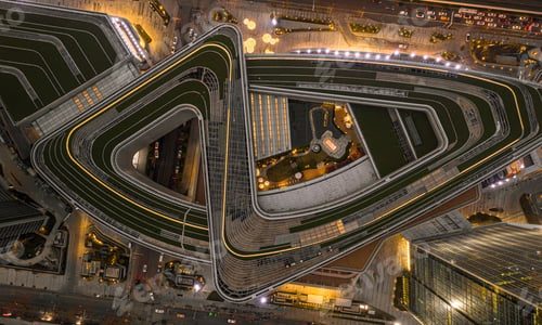 Preview: Aerial view of a busy city intersection at night with multiple cars driving along roads