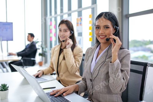 Preview: female operator agent with headsets and her team working in a call center customer service office.