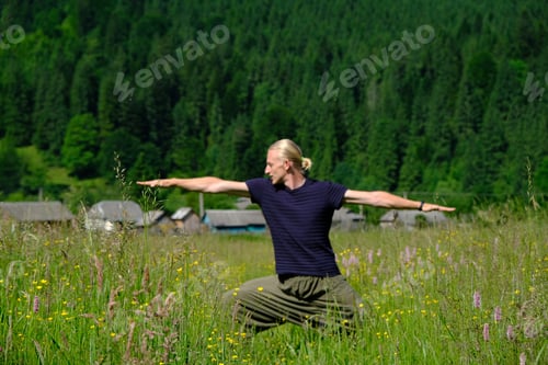Preview: Man practicing yoga exercises on a sunny day in the mountains forest. Summer vacations outdoor