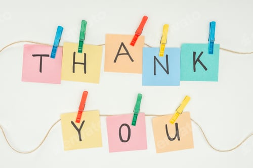 Preview: colorful sticky notes spelling thank you on lace with clothespins isolated on white background