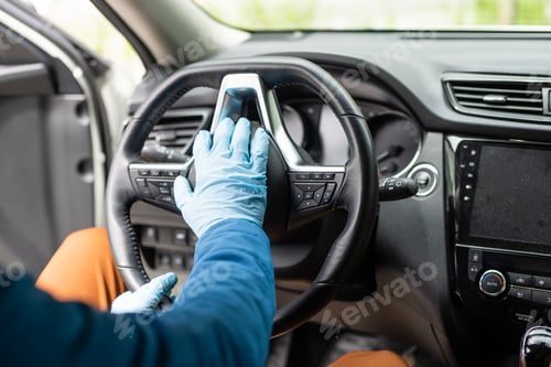 Preview: Covid-19 concept. Man drives in car, wears medical gloves, protects himself from bacteria and virus