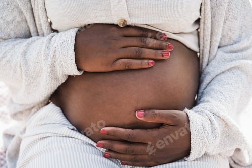 Preview: Close up of african pregnant woman holding her belly - Focus on hands