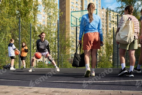 Preview: Teenage Boy Dribbling Basketball While Friends Watching on Outdoor Court